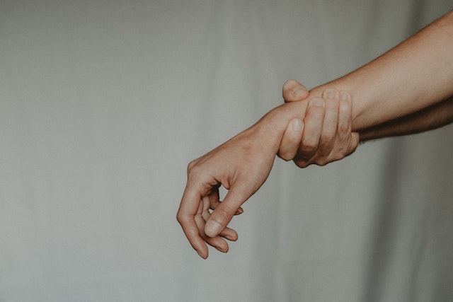 person holding their wrist in pain
